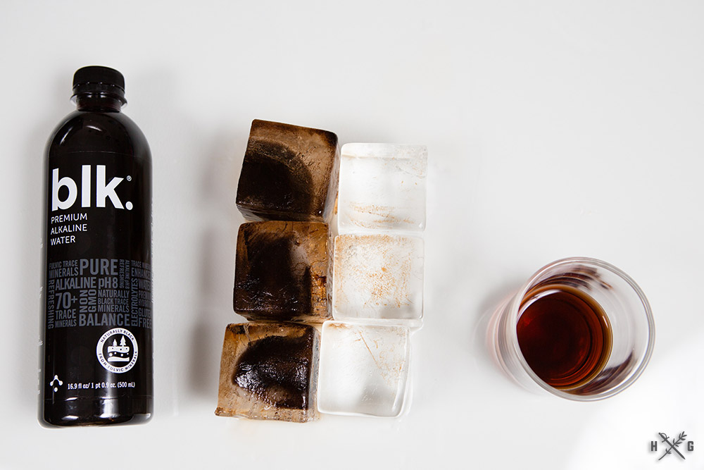 BLK. Alkaline Water, black ice cubes, clear ice cubes, glass of BLK. (black) water